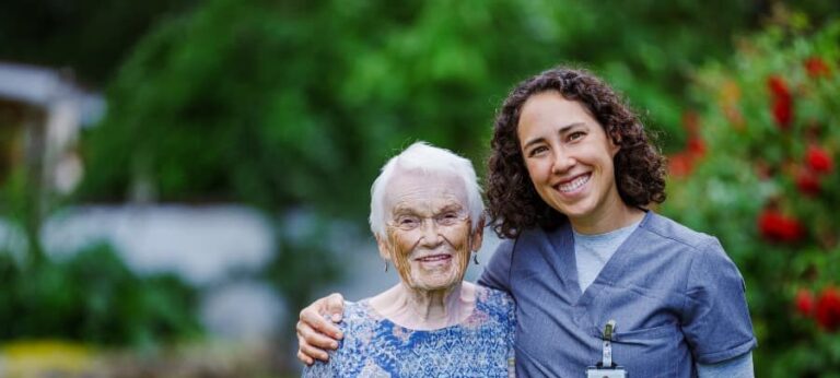 Home health nurse smiling with senior outdoors