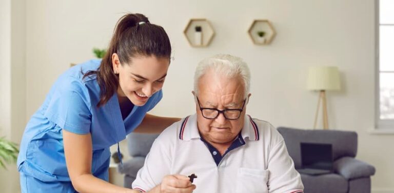 Nurse with resident helping with alphabet puzzle sitting at desk and working on therapy